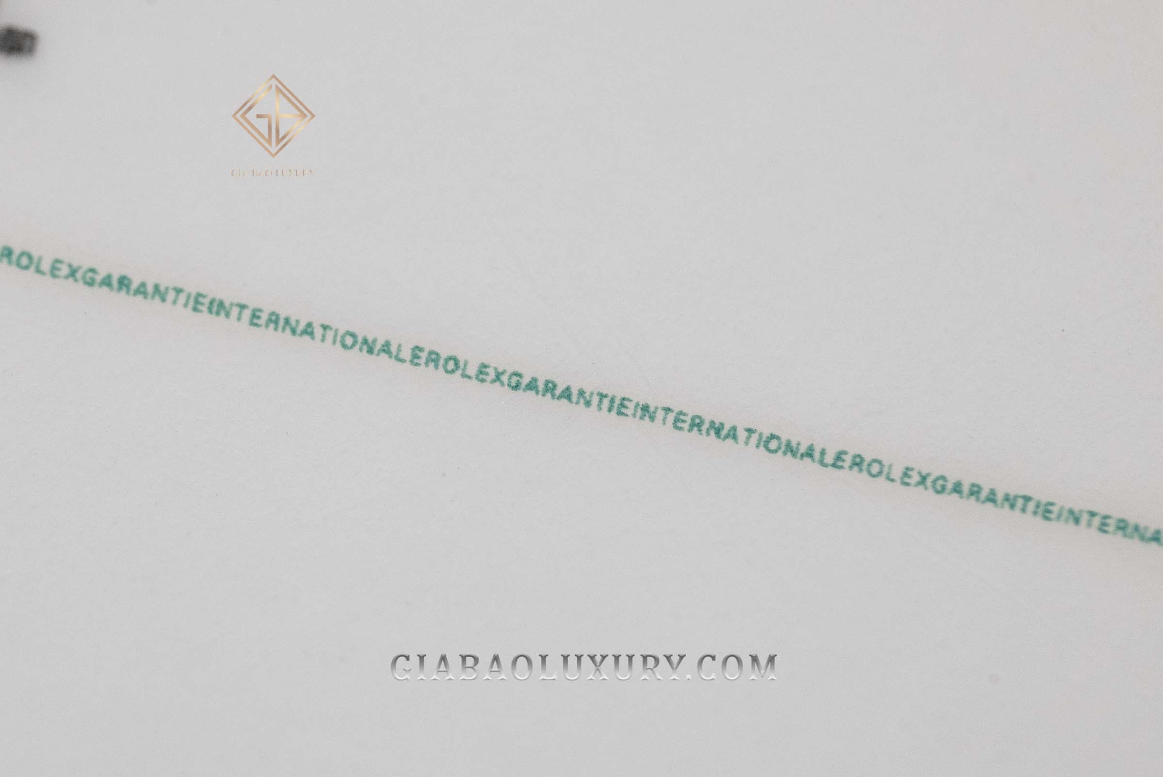 Dòng vi chữ trên một thẻ bảo hành Rolex xanh trắng chụp bởi Gia Bảo